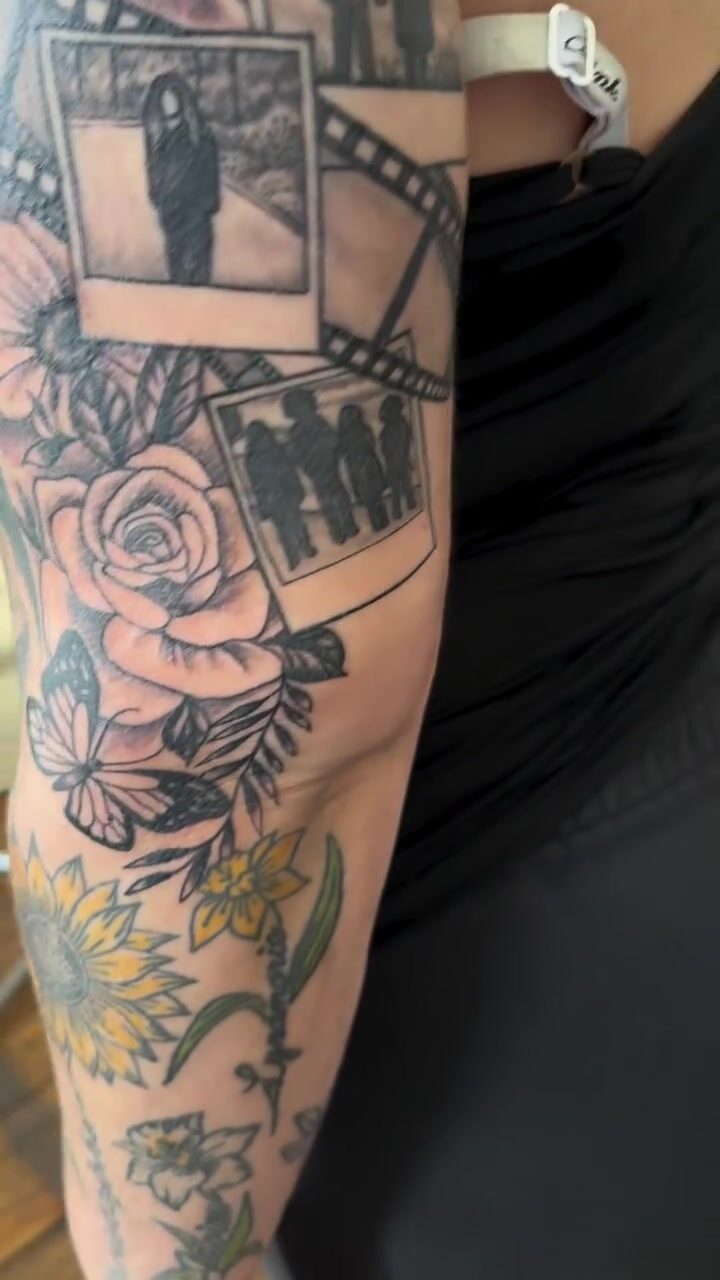Black and gray film strip and roses sleeve tattoo with color sunflowers