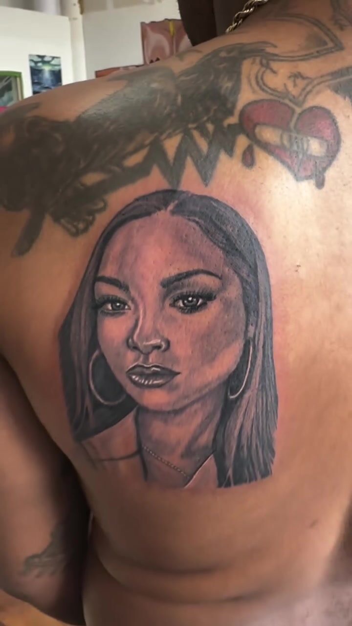 Black and gray portrait of a woman tattoo on an upper back